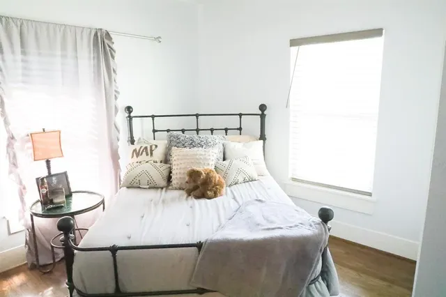 a bedroom with a bed and wooden floor