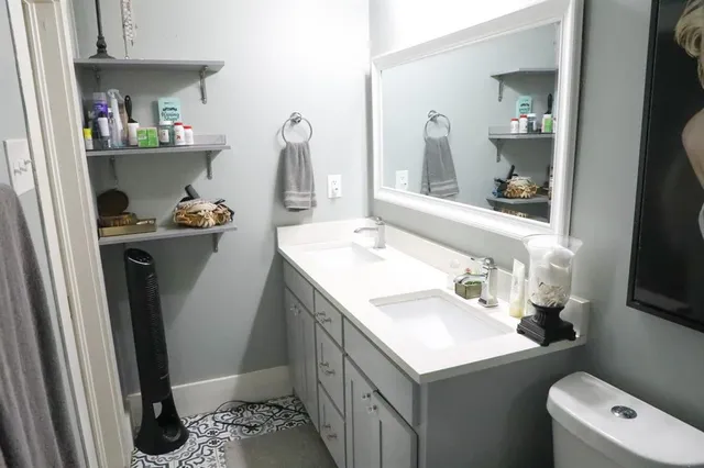 a bathroom with a sink a toilet and a mirror