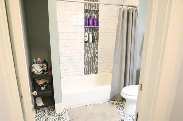 a bathroom with a toilet and a shower curtain