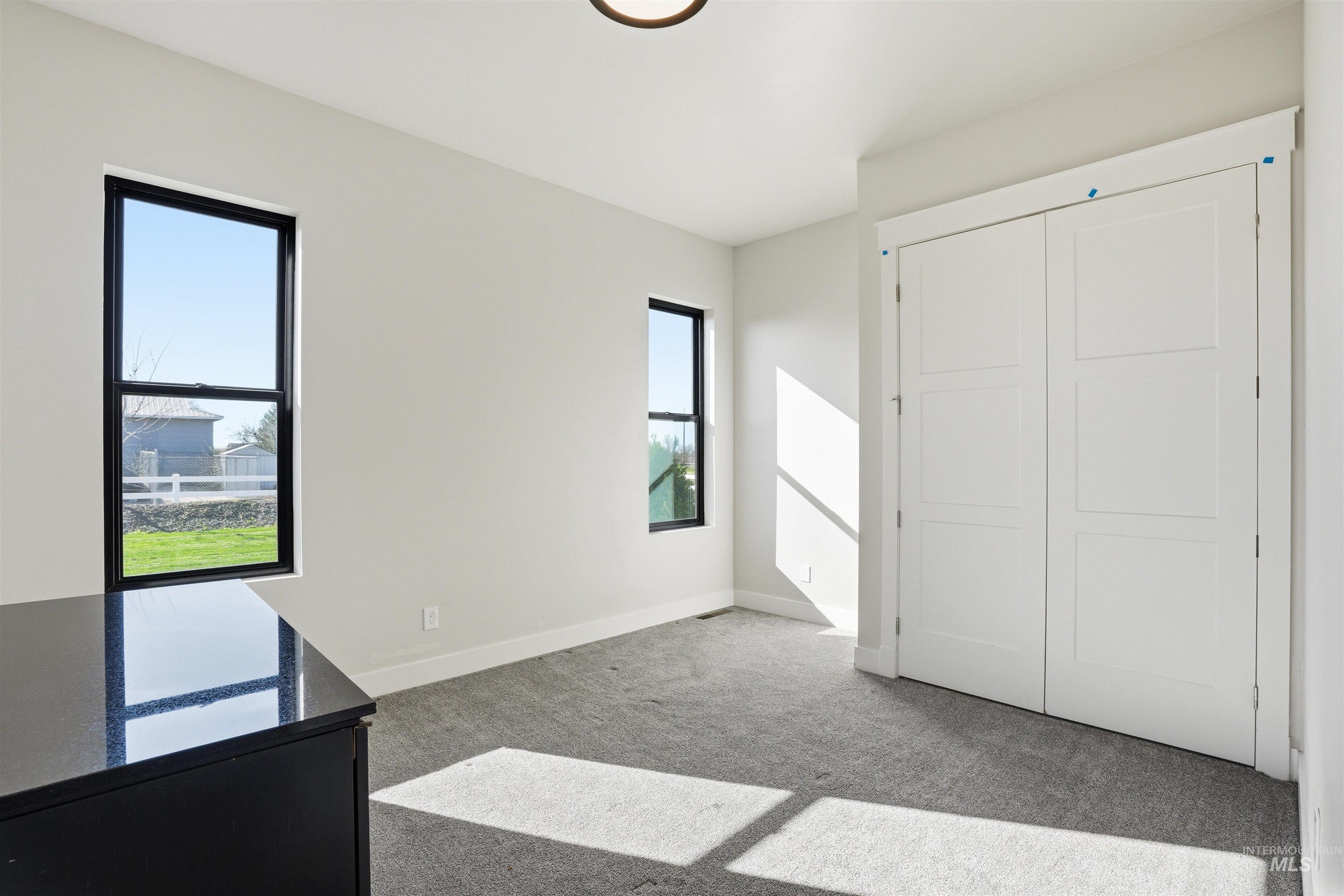 320 West Homedale Road Caldwell, ID 83607 - Photo 16 of 48 Unfurnished bedroom featuring light colored carpet and baseboards