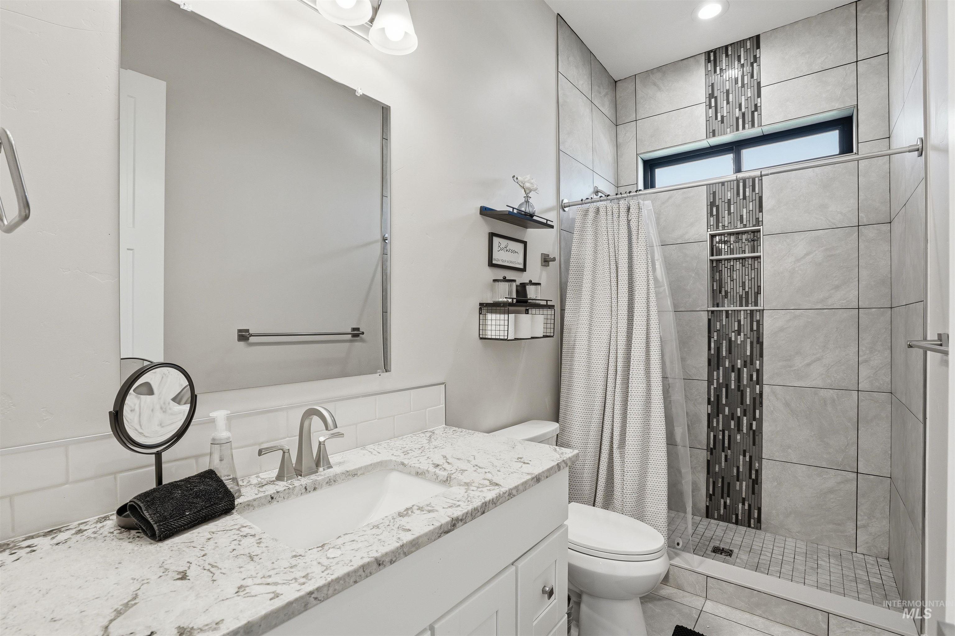 320 West Homedale Road Caldwell, ID 83607 - Photo 17 of 48 Full bath with vanity, a shower stall, and light tile patterned floors