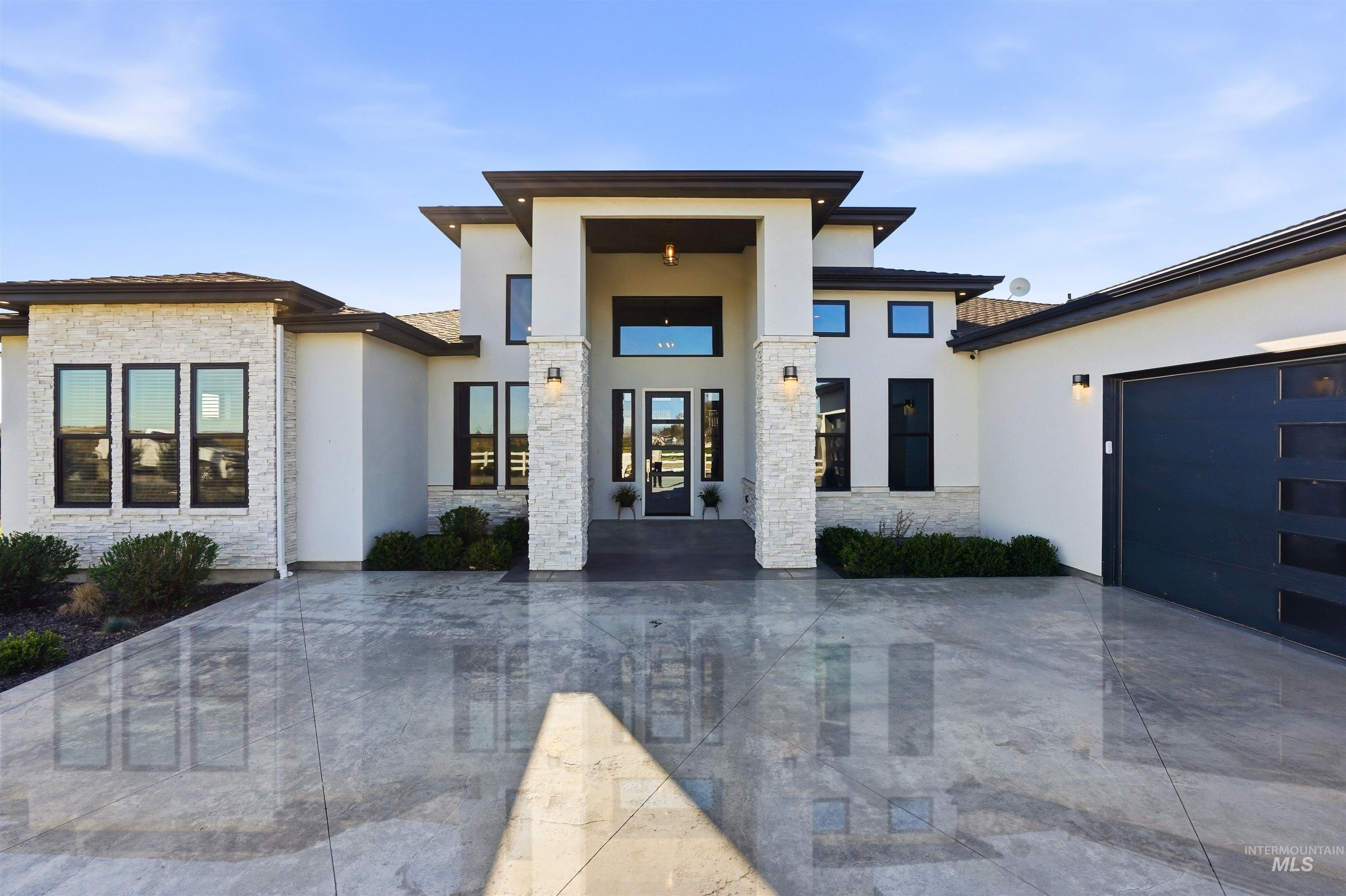 320 West Homedale Road Caldwell, ID 83607 - Photo 2 of 48 Entrance to property with stucco siding, stone siding, driveway, and an attached garage