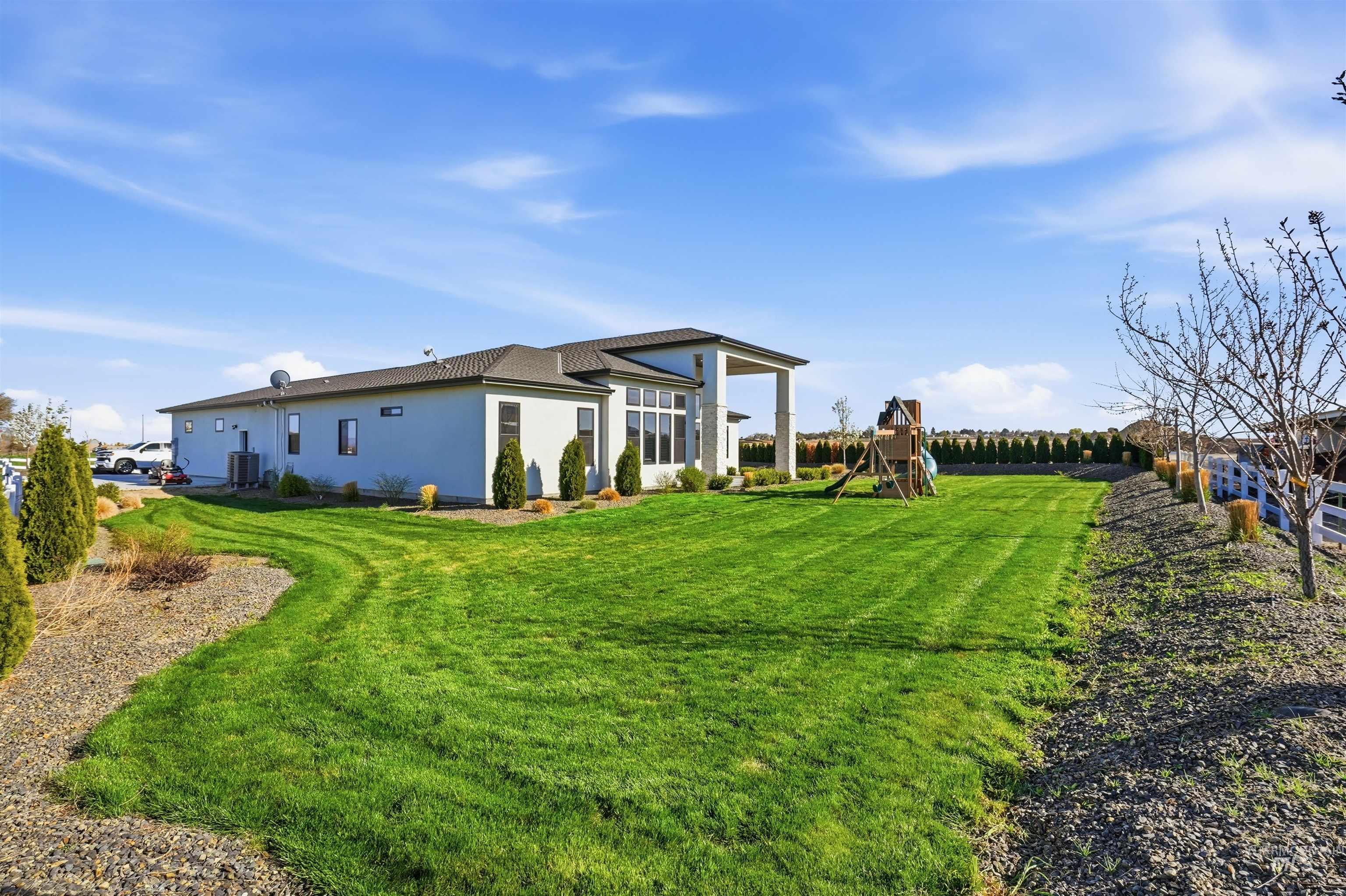 320 West Homedale Road Caldwell, ID 83607 - Photo 39 of 48 Back of property with a playground, stucco siding, and a yard