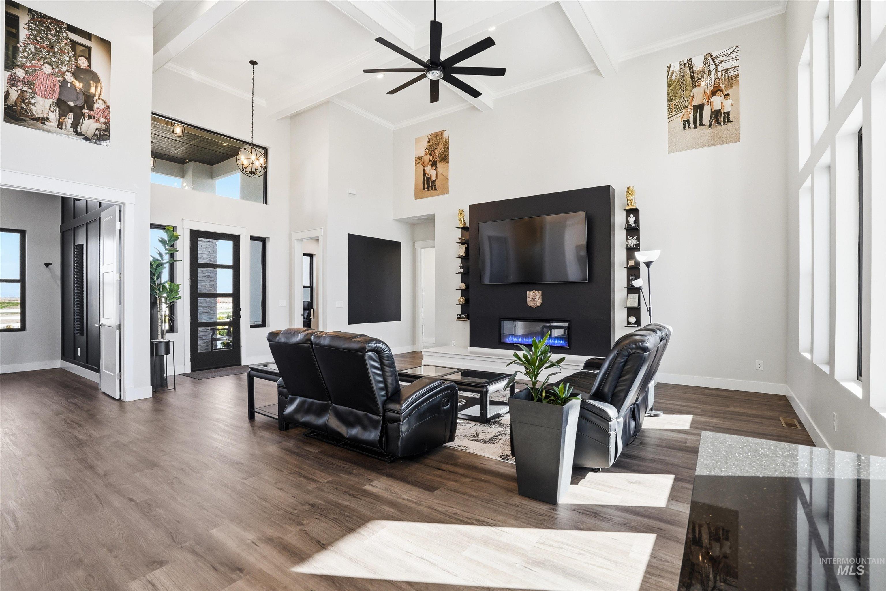 320 West Homedale Road Caldwell, ID 83607 - Photo 7 of 48 Living room with dark wood-style flooring, healthy amount of natural light, a glass covered fireplace, and ceiling fan