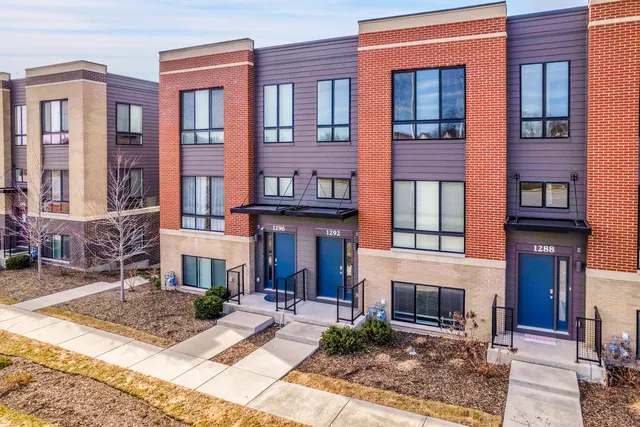 a view of a building with many windows yard and large tree