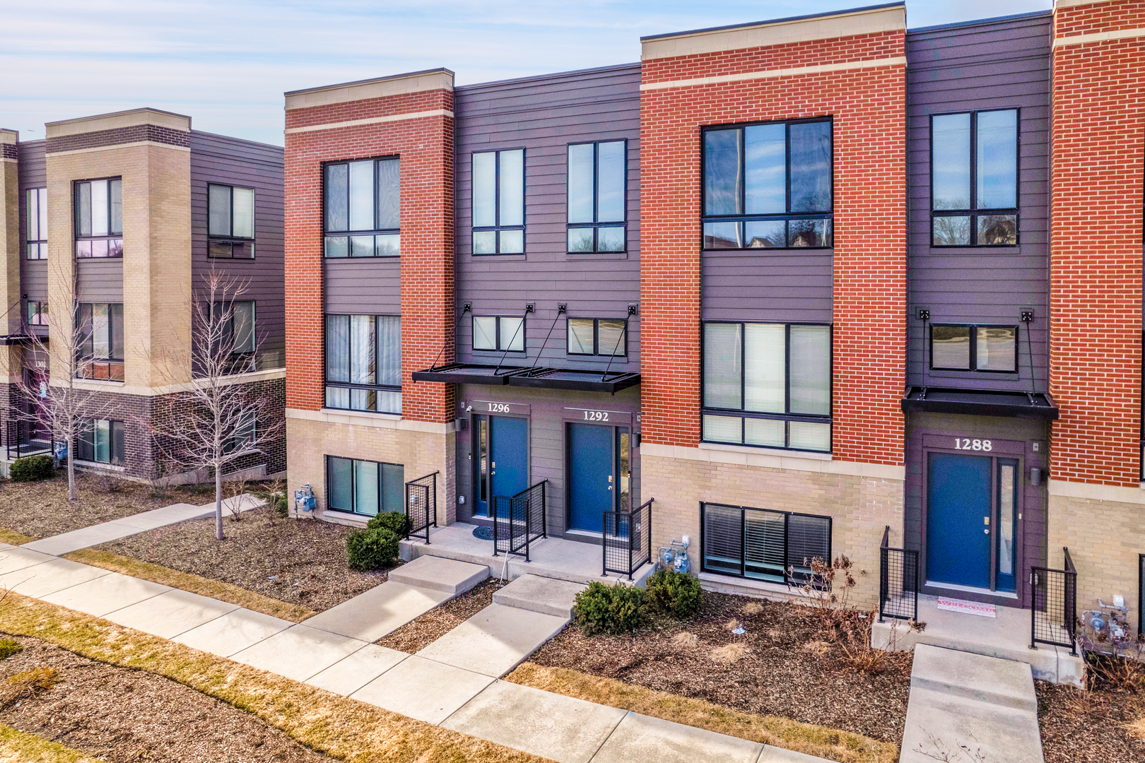 a view of a building with many windows yard and large tree