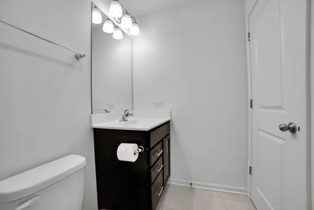 a bathroom with a bathtub shower sink vanity mirror and toilet