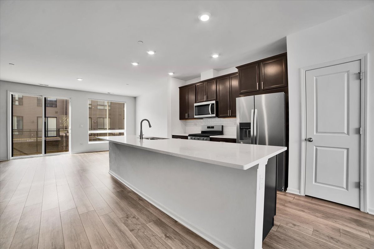 1292 Quadrant Lane Schaumburg, IL 60173 - Photo 4 of 39 a large kitchen with a center island wooden floor and stainless steel appliances