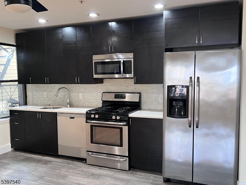 a kitchen with a refrigerator and a stove top oven
