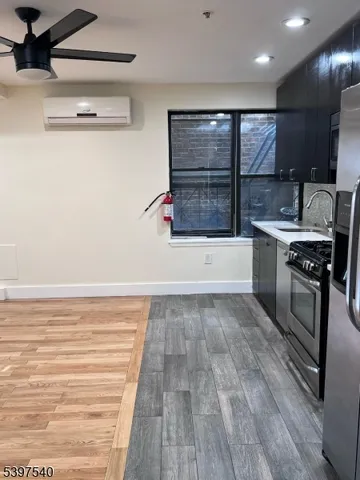 a view of kitchen with a sink wooden floor and living room