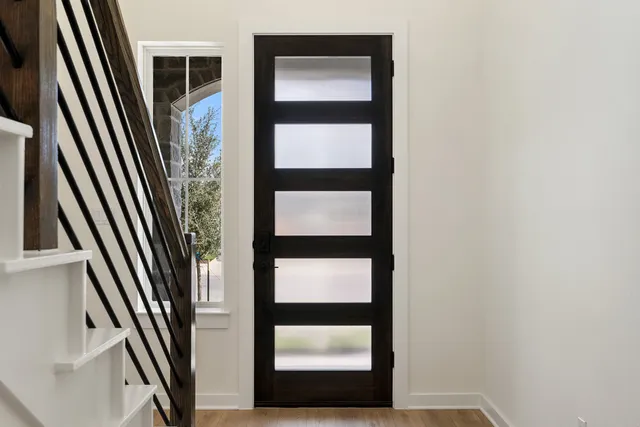a view of a hallway with wooden floor and stairs