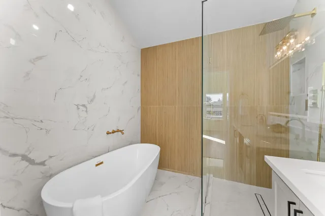 a bathroom with a tub a sink and shower