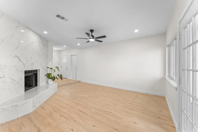 an empty room with a fireplace and fan