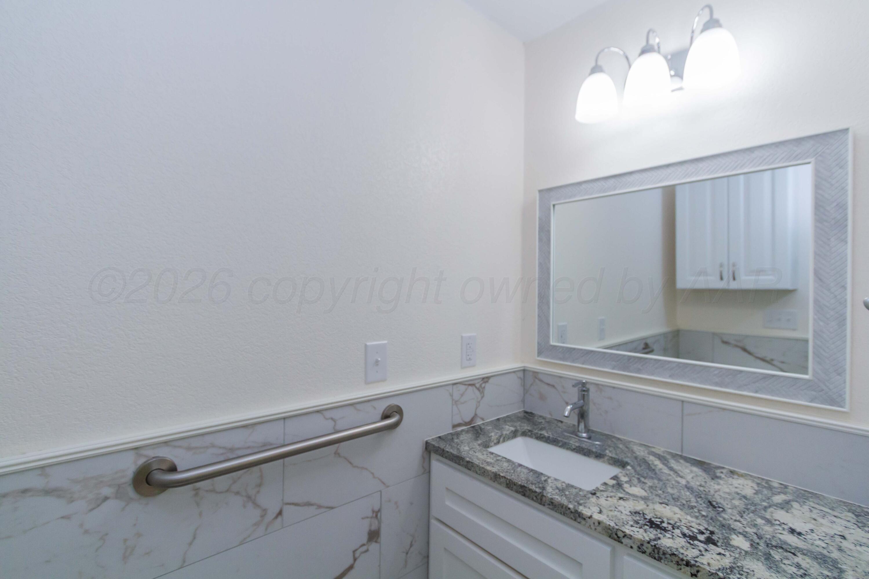 706 Pittsburg Street Amarillo, TX 79104 - Photo 11 of 22 a bathroom with a sink and a mirror