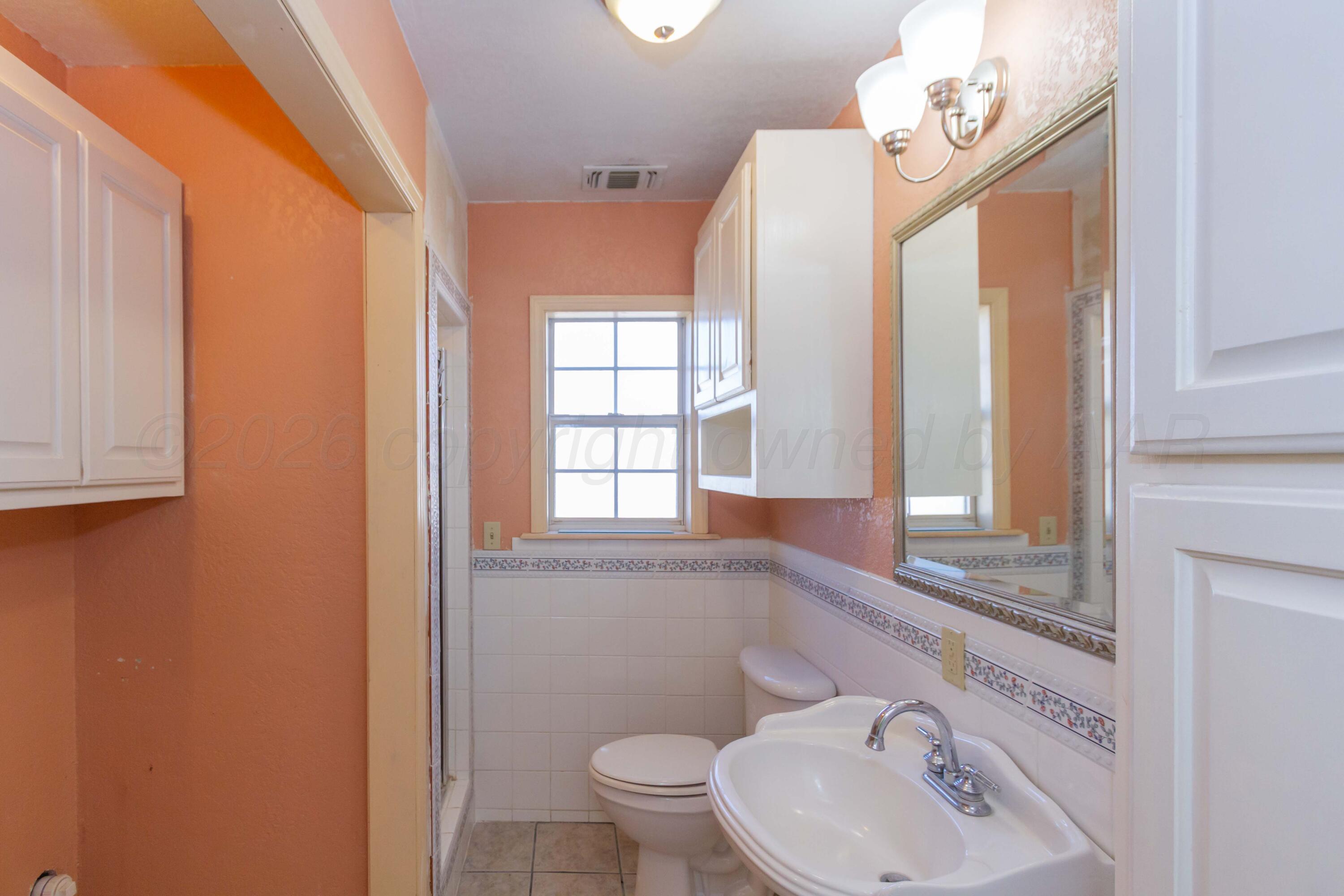 706 Pittsburg Street Amarillo, TX 79104 - Photo 15 of 22 a bathroom with a sink a toilet and a mirror