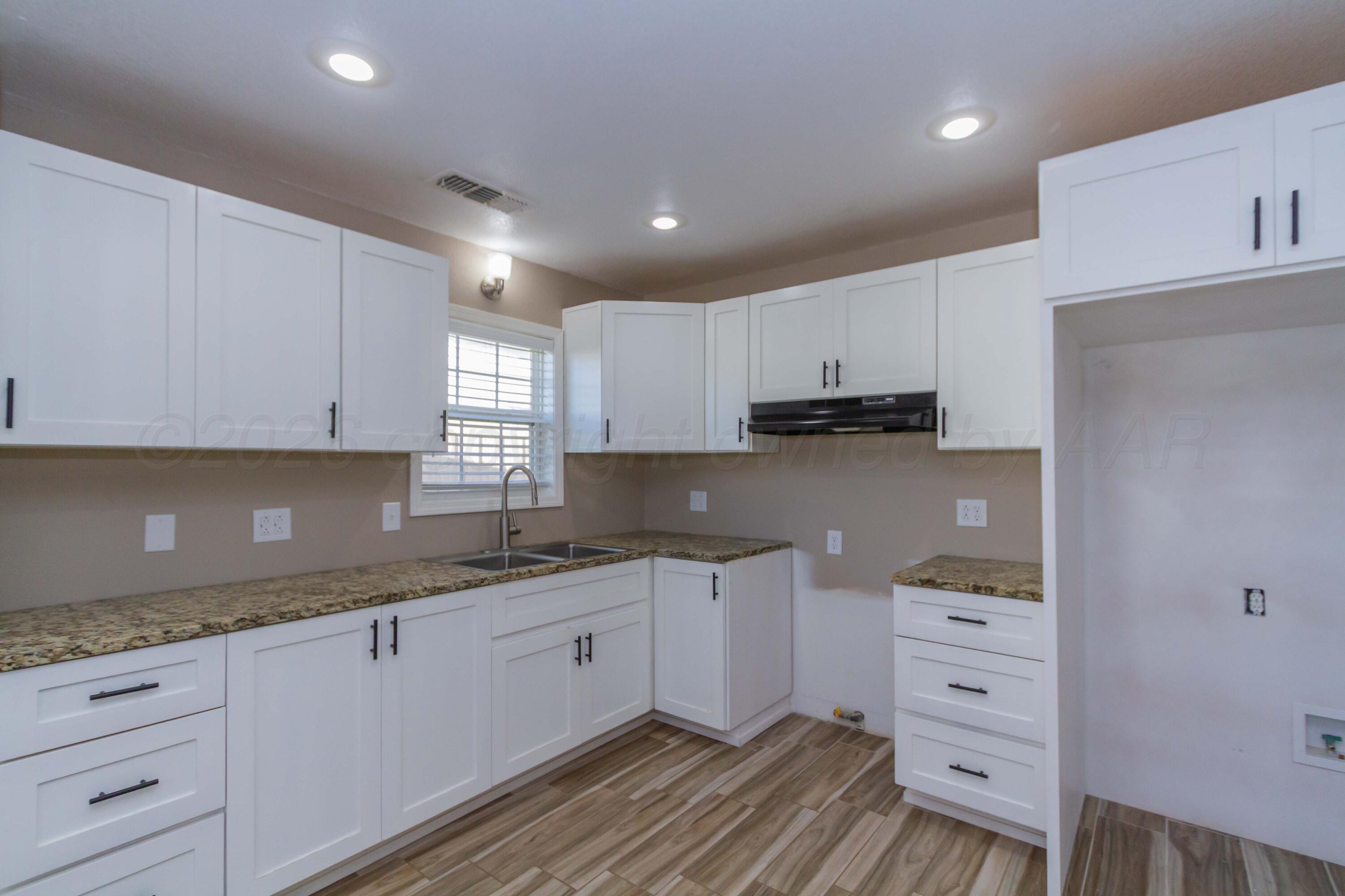 706 Pittsburg Street Amarillo, TX 79104 - Photo 6 of 22 a kitchen with granite countertop white cabinets and white appliances