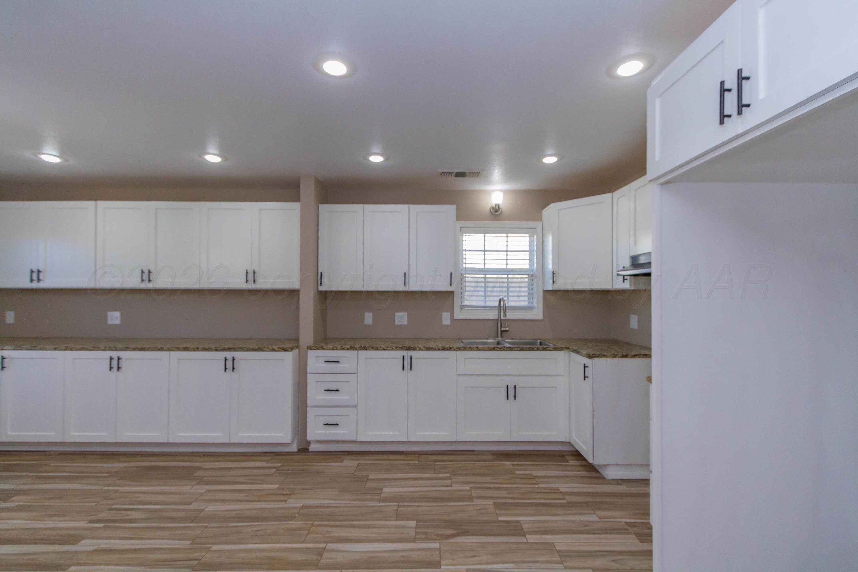 706 Pittsburg Street Amarillo, TX 79104 - Photo 7 of 22 a kitchen with granite countertop a sink and cabinets