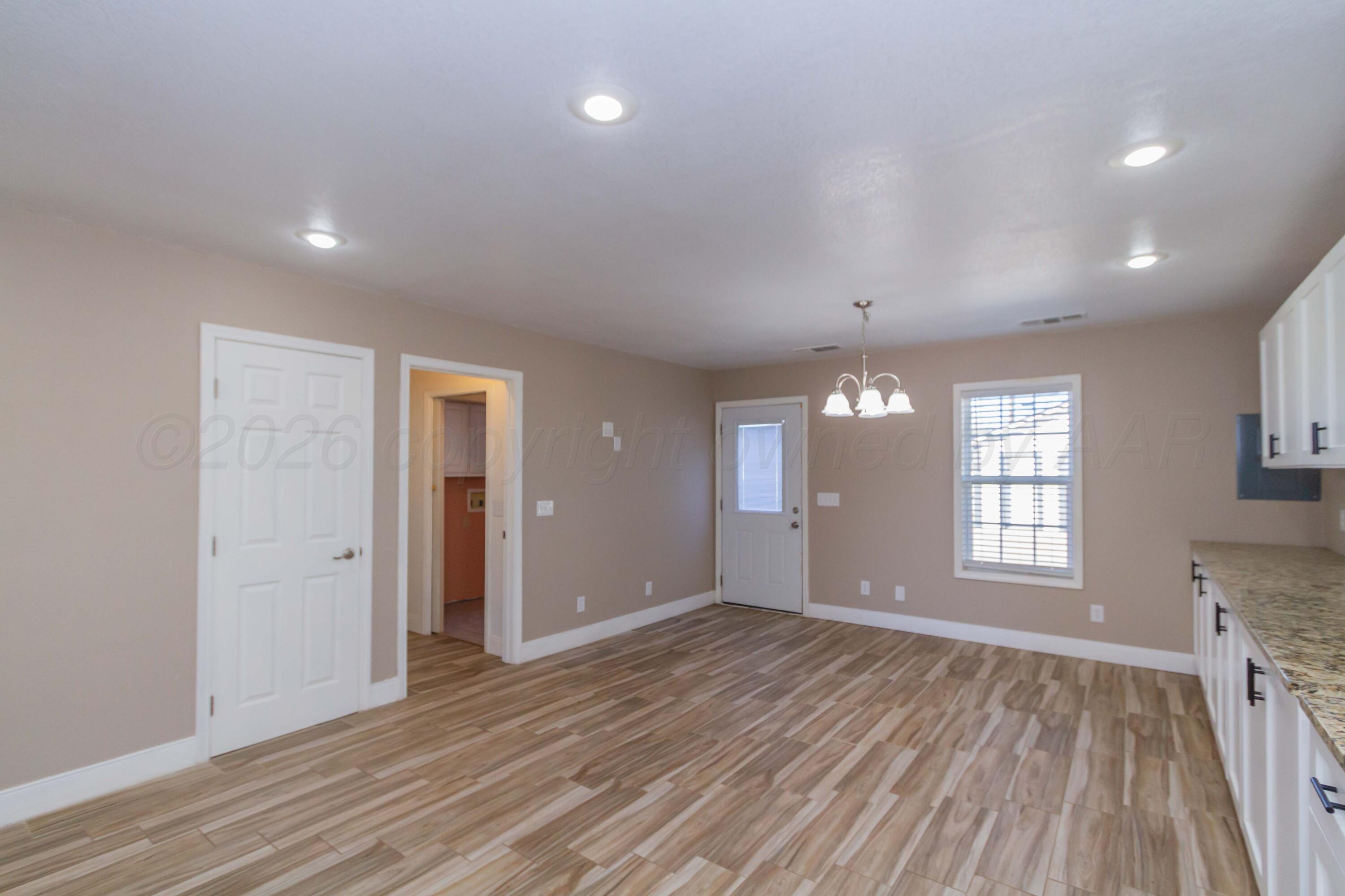 706 Pittsburg Street Amarillo, TX 79104 - Photo 8 of 22 wooden floor in an empty room with a window