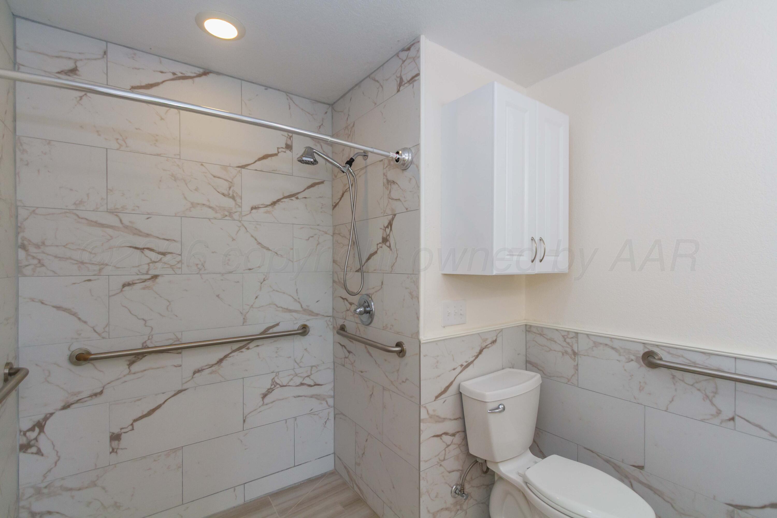 706 Pittsburg Street Amarillo, TX 79104 - Photo 10 of 22 a bathroom with a toilet and shower