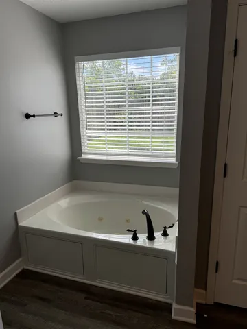 a bathroom with a bathtub and a window