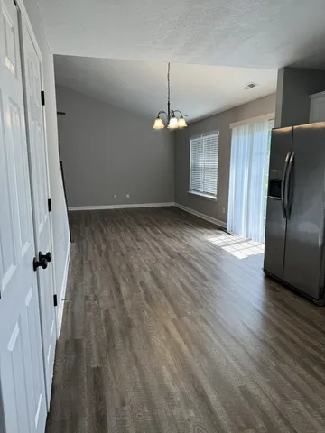 an empty room with wooden floor and staircase