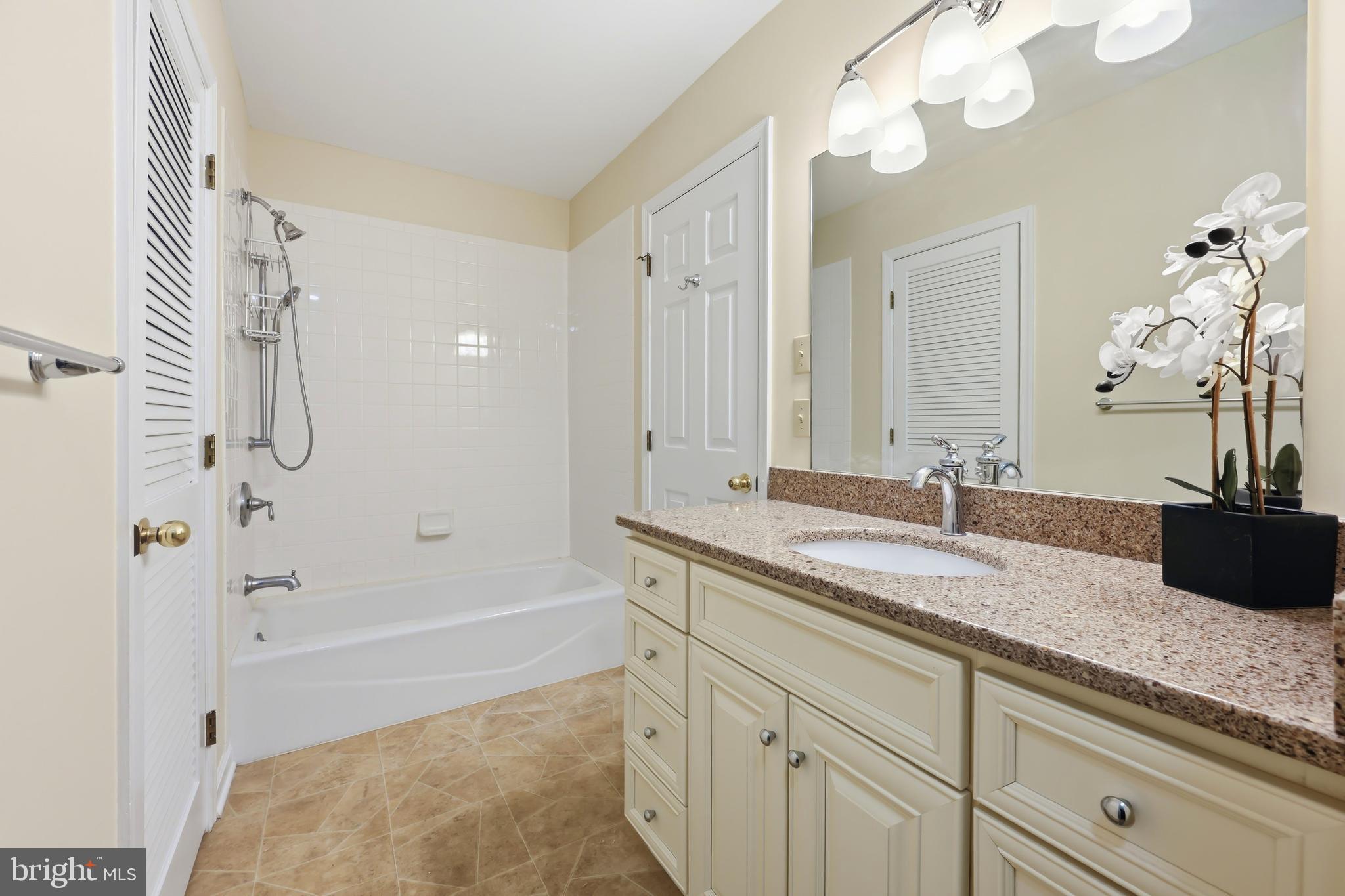 25714 Edgeview Road Royal Oak, MD 21662 - Photo 19 of 39 a bathroom with a granite countertop sink a mirror and a bathtub