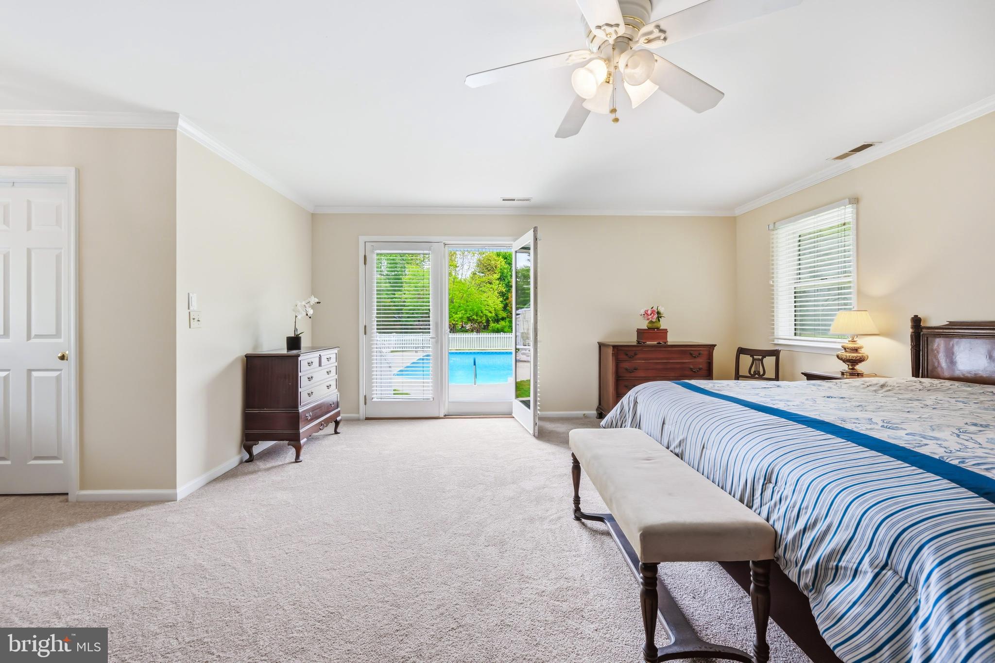 25714 Edgeview Road Royal Oak, MD 21662 - Photo 21 of 39 a spacious bedroom with a bed a chandelier and large window