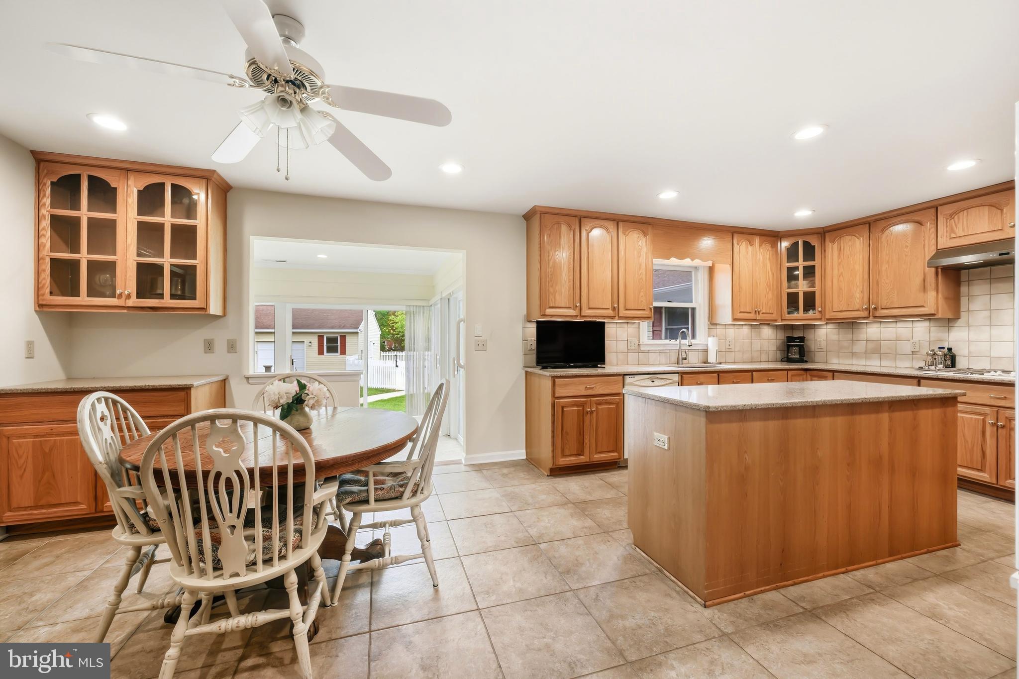 25714 Edgeview Road Royal Oak, MD 21662 - Photo 9 of 39 a kitchen with granite countertop a table chairs a sink dishwasher refrigerator and cabinets