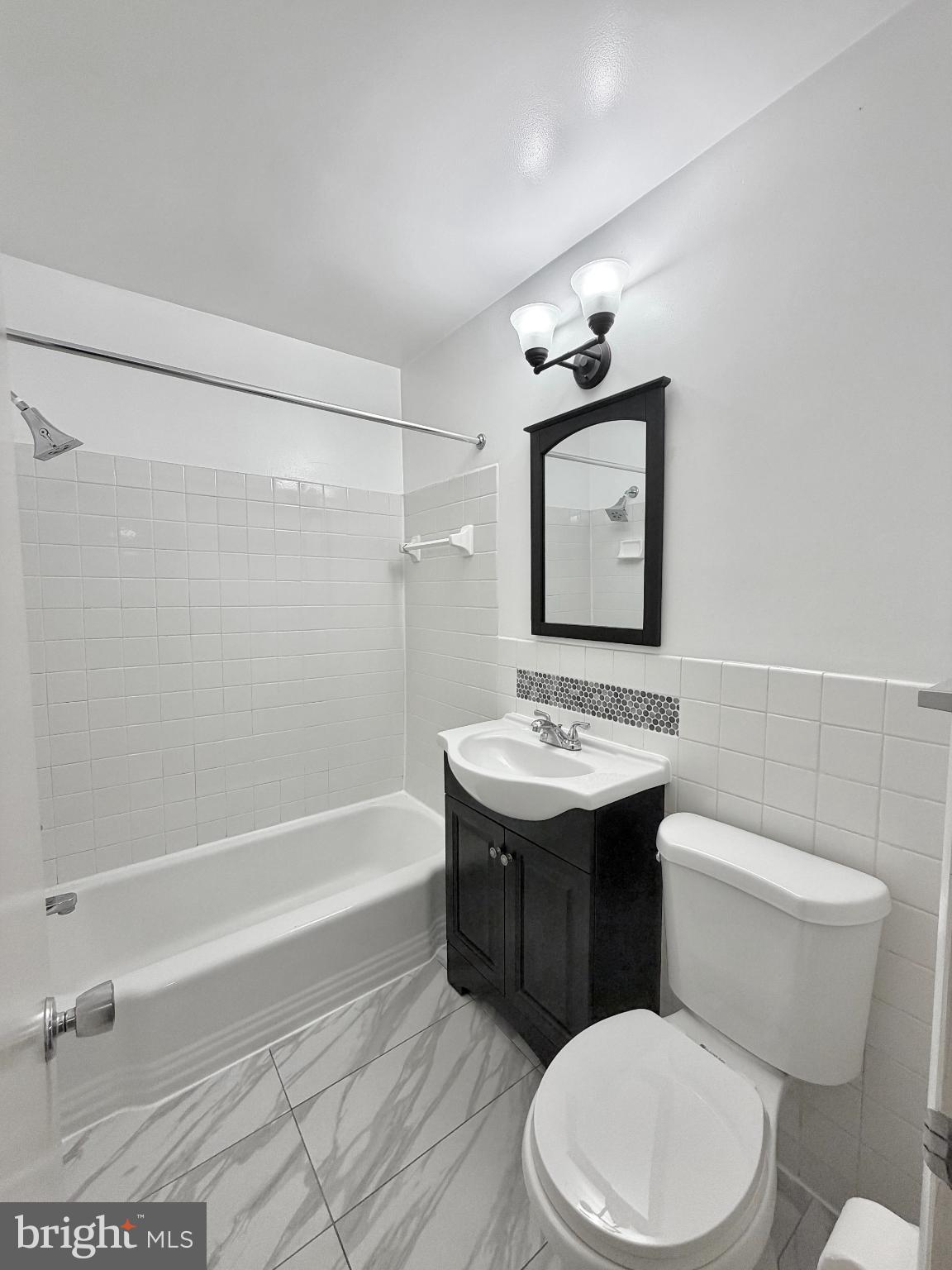 10661 Weymouth Street, Unit 101 Bethesda, MD 20814 - Photo 12 of 23 a bathroom with a sink a toilet and mirror