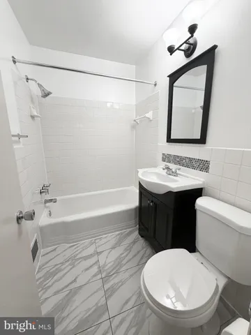 an empty room with a windows and chandelier fan