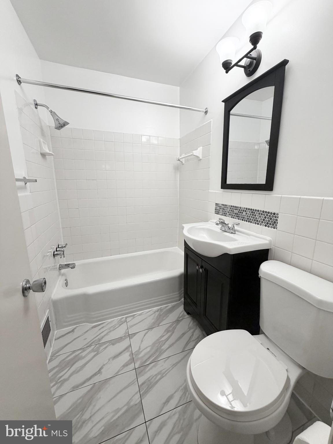 10661 Weymouth Street, Unit 101 Bethesda, MD 20814 - Photo 13 of 23 a bathroom with a sink toilet and shower