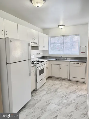 a kitchen with a stove a sink and a window