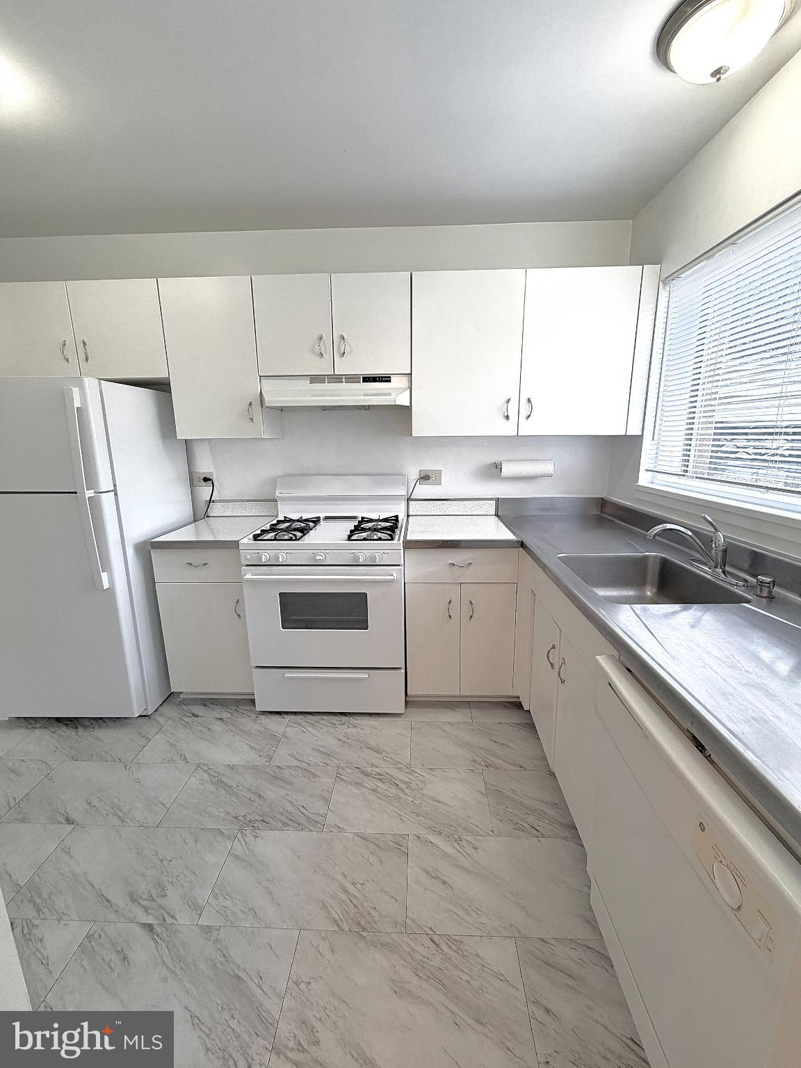 10661 Weymouth Street, Unit 101 Bethesda, MD 20814 - Photo 4 of 23 a kitchen with a stove a sink and a window