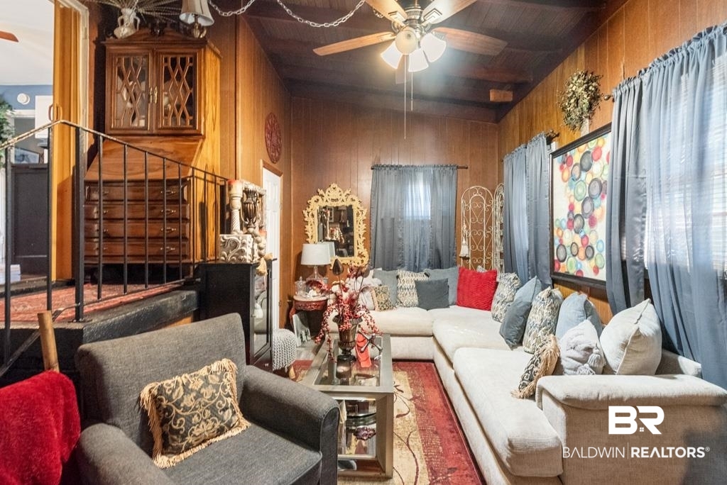 109 Esplanade Avenue Mobile, AL 36606 - Photo 31 of 45 Living room featuring wood walls, a ceiling fan, stairs, and a wooden ceiling with exposed beams