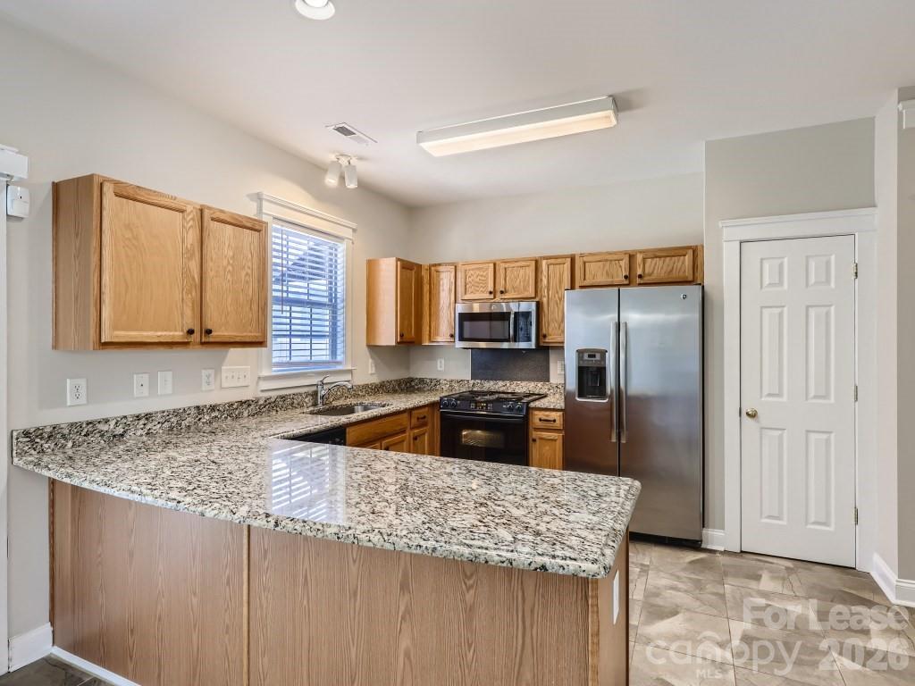 249 Faust Road Davidson, NC 28036 - Photo 3 of 21 a kitchen with stainless steel appliances granite countertop a sink a stove and a refrigerator