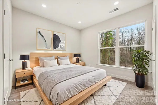 a bedroom with a large bed and a potted plant