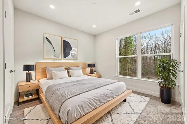 a bedroom with a large bed and a potted plant