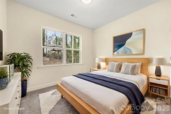 a bedroom with a bed and a potted plant