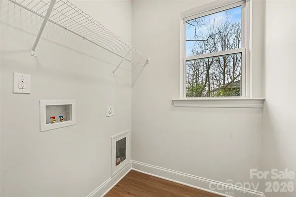 a view of a small space with wooden floor and a window
