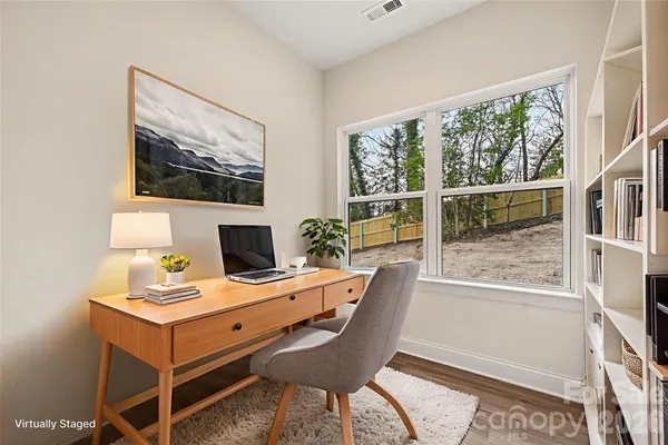 a view of a workspace with furniture and a window