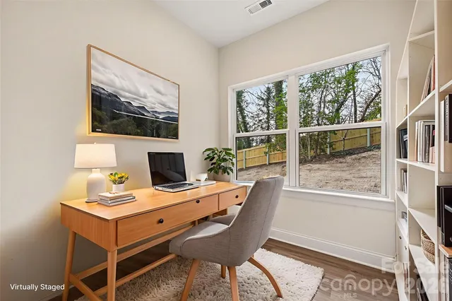 a view of a workspace with furniture and a window