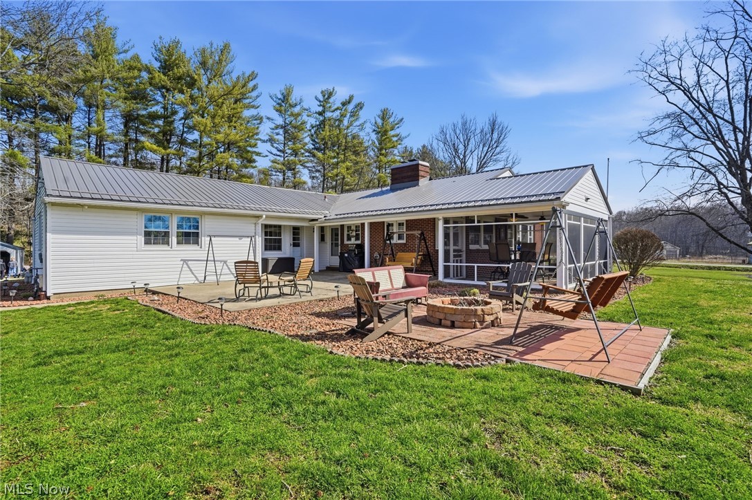 6655 Ceramic Road Crooksville, OH 43731 - Photo 2 of 34 Rear view of house with an outdoor fire pit, a sunroom, a chimney, a yard, and a patio area
