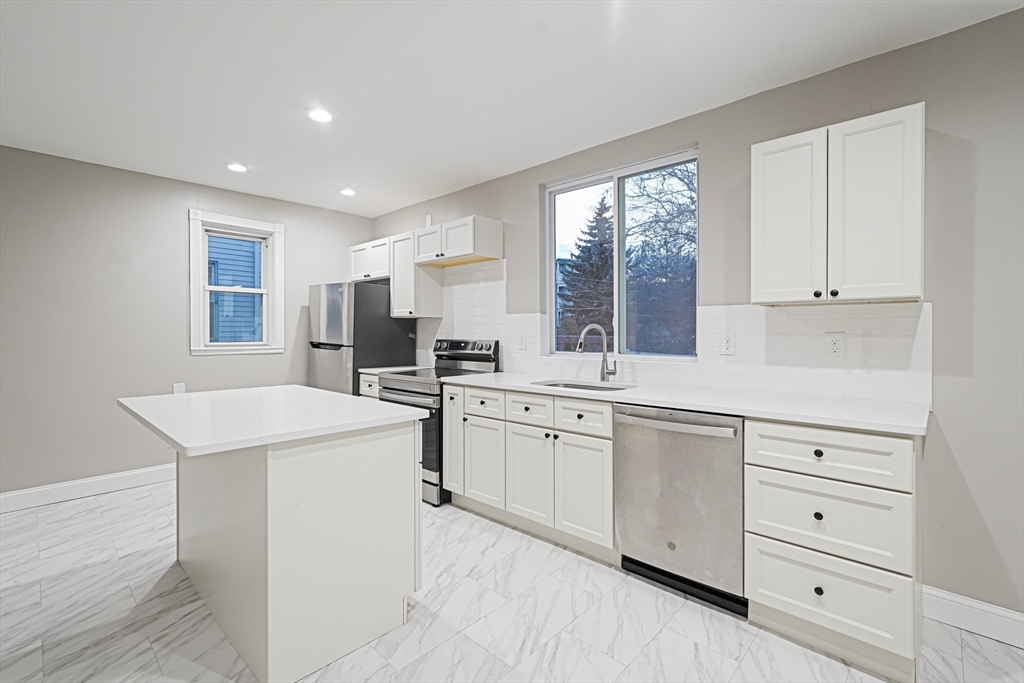 a kitchen with white cabinets and white appliances