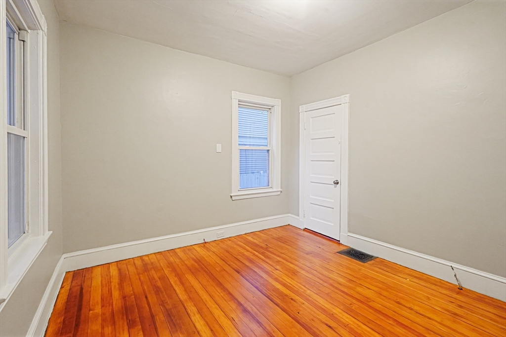 381 Adams Street, Unit 1 Boston, MA 02122 - Photo 14 of 42 a view of a room with wooden floor and white walls