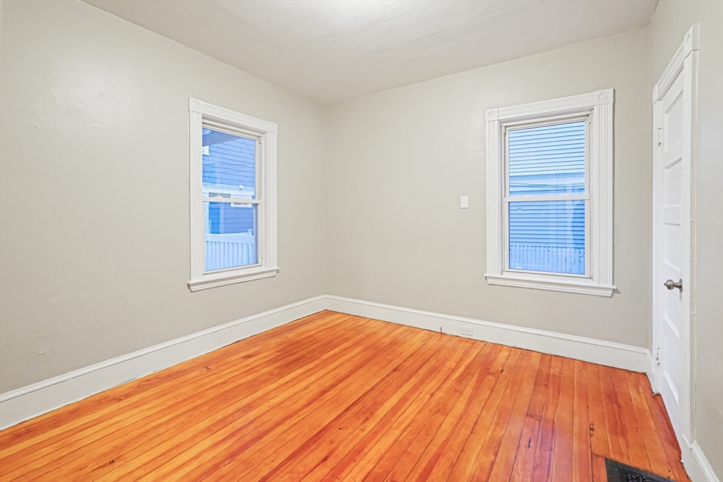 381 Adams Street, Unit 1 Boston, MA 02122 - Photo 16 of 42 a view of an empty room with wooden floor and a window