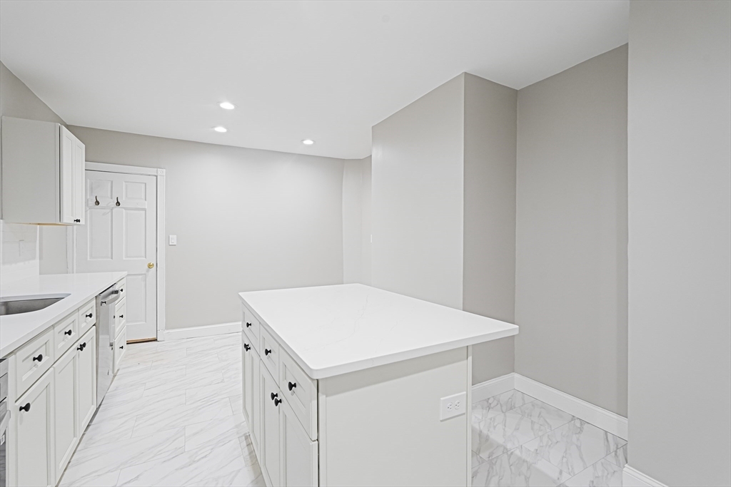 381 Adams Street, Unit 1 Boston, MA 02122 - Photo 2 of 42 a hallway with cabinets washer and dryer