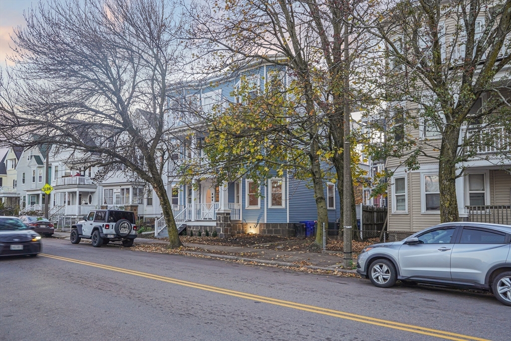 381 Adams Street, Unit 1 Boston, MA 02122 - Photo 31 of 42 a car parked in front of a white house
