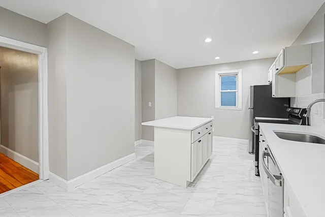 a kitchen with a sink a stove cabinets and a wooden floor