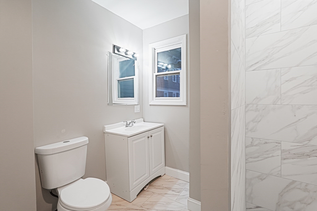 381 Adams Street, Unit 1 Boston, MA 02122 - Photo 7 of 42 a white toilet sitting next to a bathroom sink