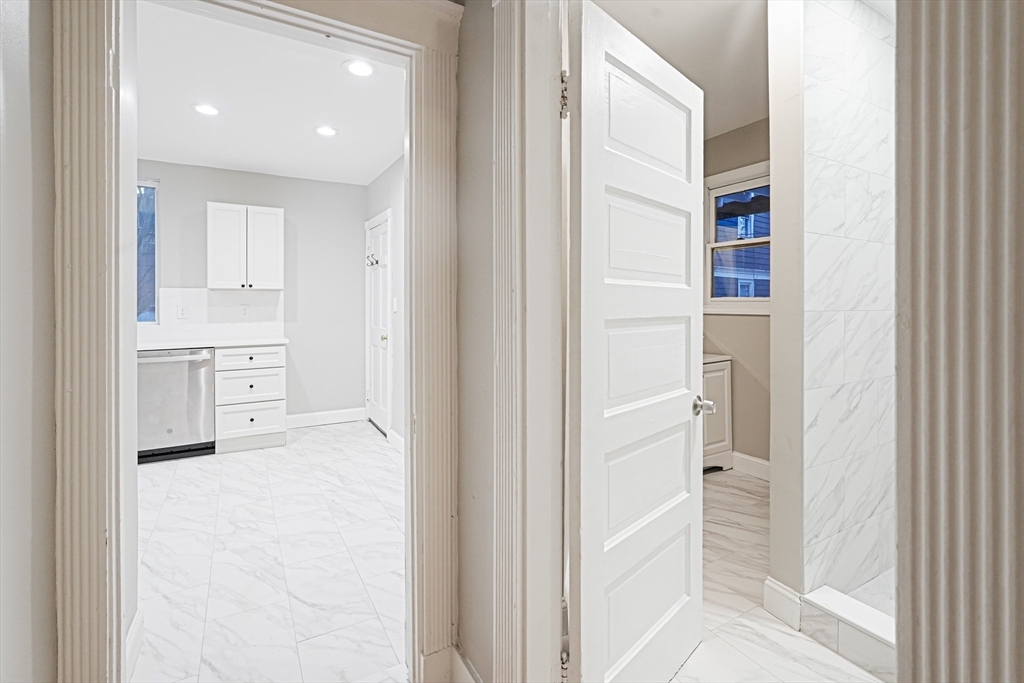 381 Adams Street, Unit 1 Boston, MA 02122 - Photo 10 of 42 a view of a kitchen with white cabinets and a refrigerator